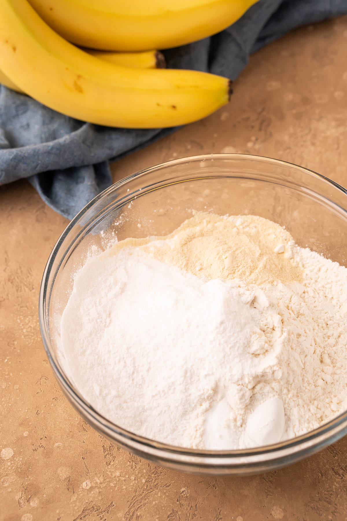 Flour, pudding mix, and malted milk powder in a glass mixing bowl.