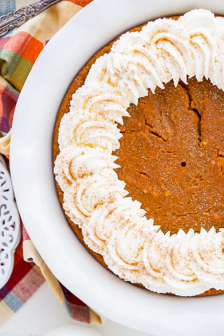 This Impossible Pumpkin Pie Recipe is actually the easiest pumpkin pie you'll ever make! As it bakes, it forms a light crust on its own and leaves behind a dense, but creamy pumpkin filling. Top it with whipped cream and it's the perfect fall dessert!