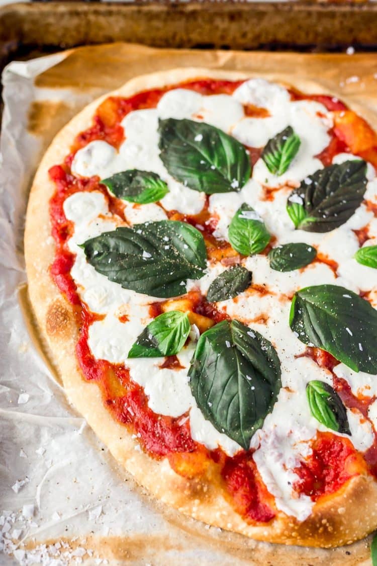 A Classic Margherita Pizza made with delicious dough, olive oil, crushed tomatoes, garlic, mozzarella, and basil always hits the spot when you need a quick and easy dinner recipe!