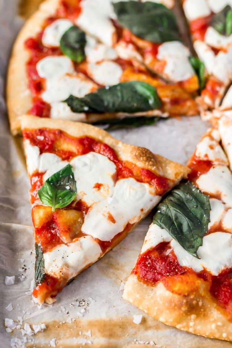 A Classic Margherita Pizza made with delicious dough, olive oil, crushed tomatoes, garlic, mozzarella, and basil always hits the spot when you need a quick and easy dinner recipe!