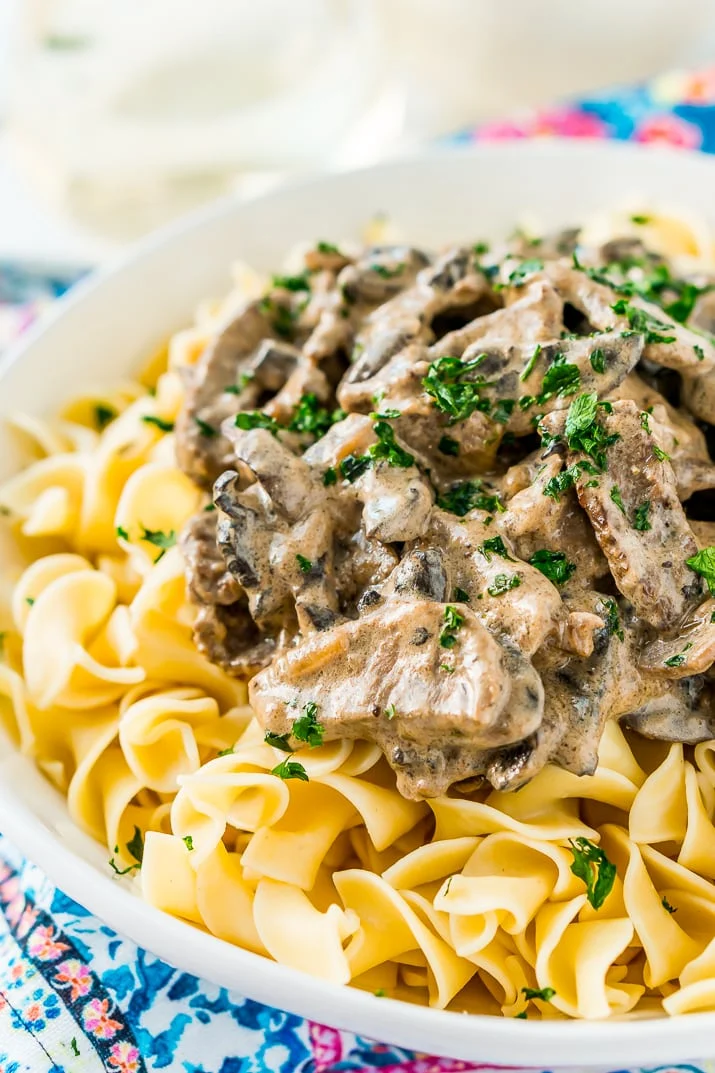 Beef Stroganoff is a delicious dinner recipe made with tender ribeye steak sautéed in a buttery mushroom and sour cream sauce and served over egg noodles.