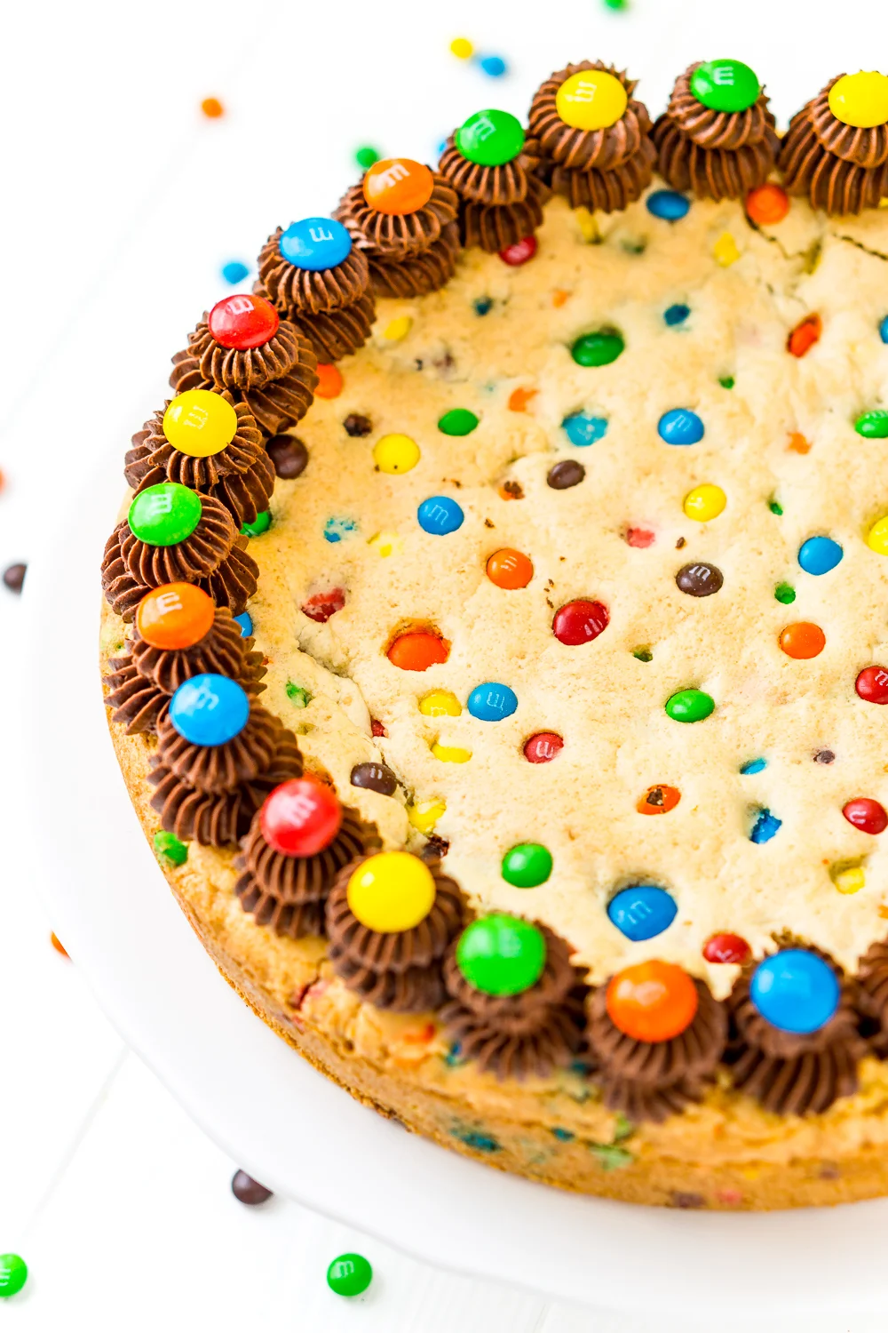 Close up of whole Cookie Cake with M&M's and chocolate frosting.