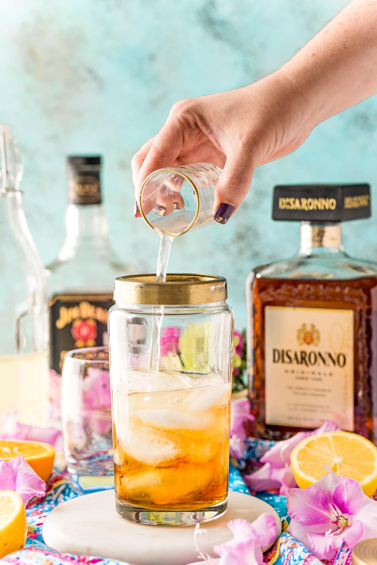 Sour mix being added to a cocktail shaker.