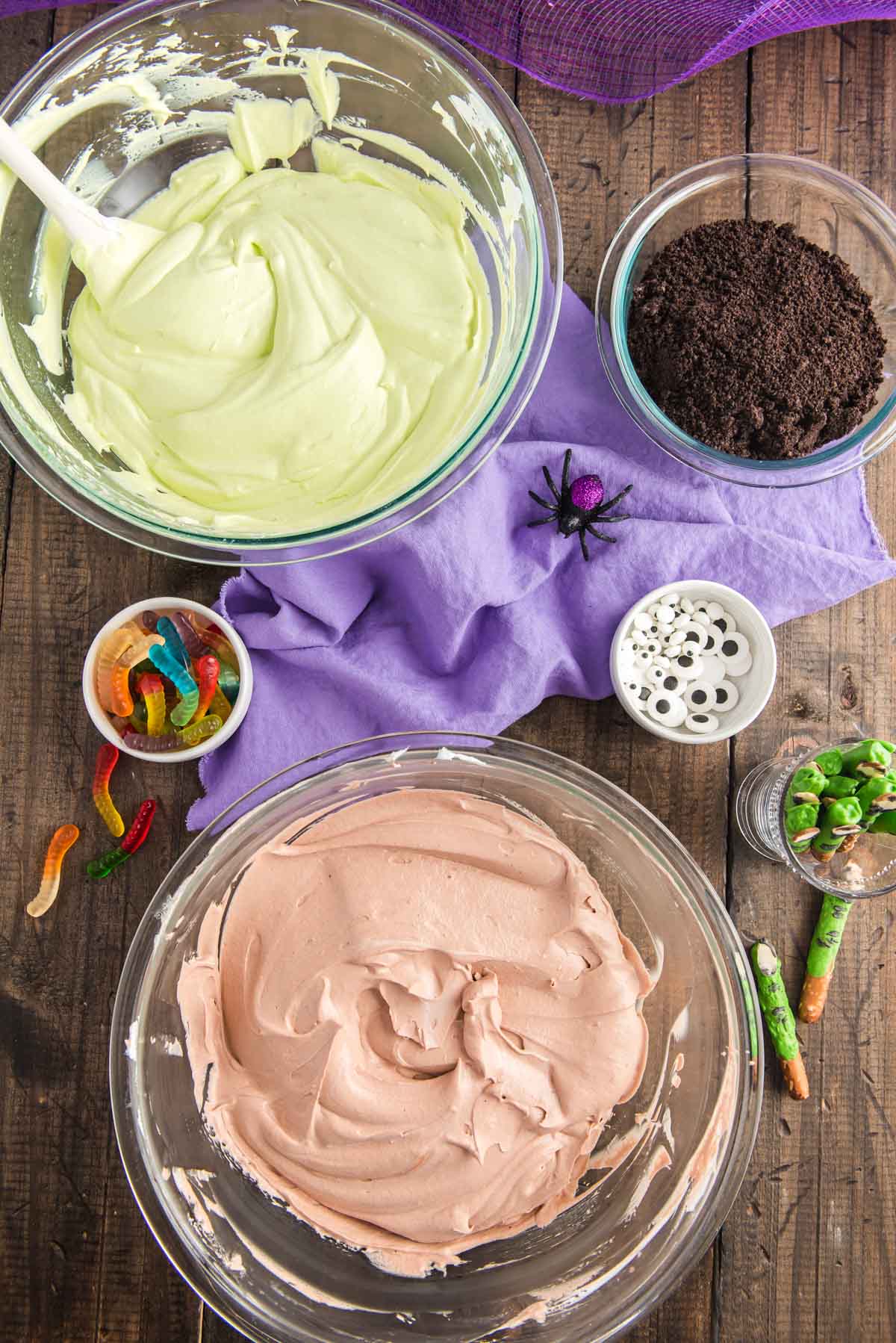 Overhead photo of bowls of pudding and cool whip and cookie crumbs to make dirt cups.