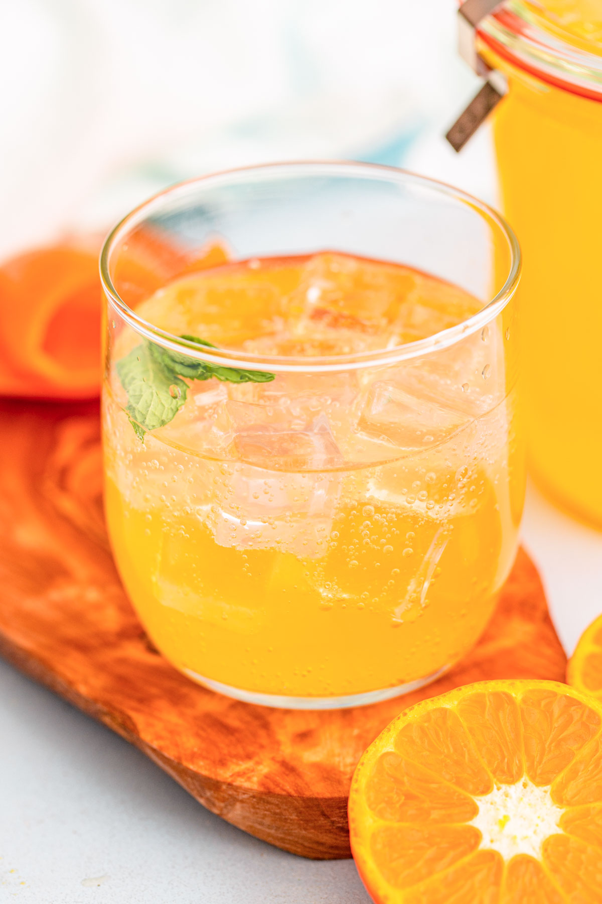 A glass with ice and orange simple syrup.