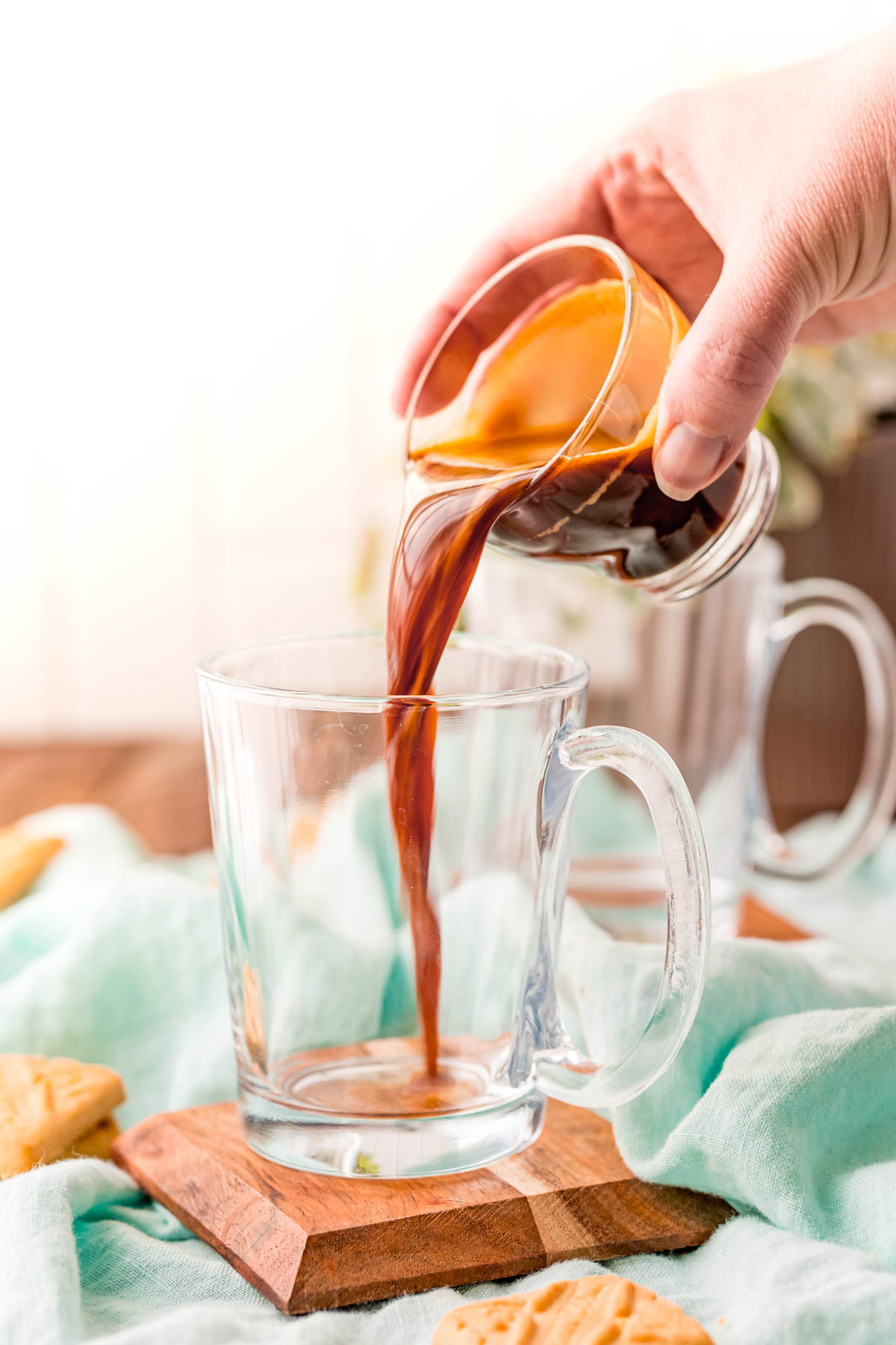 Espresso shot being poured into a glass mug.