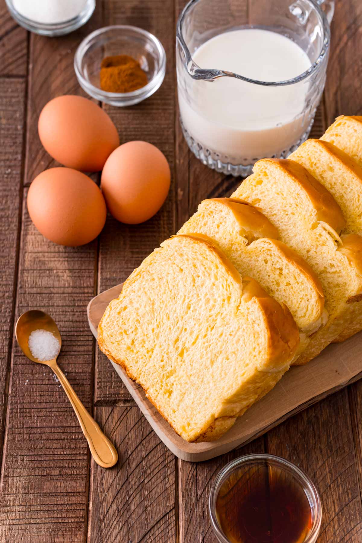 Close up photo of ingredients to make brioche French toast on a wooden table.