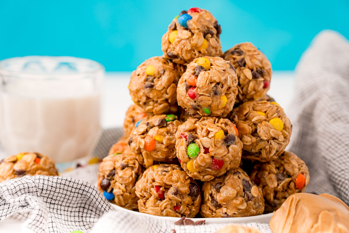Monster cookie energy balls on a white plate on a gray napkin.