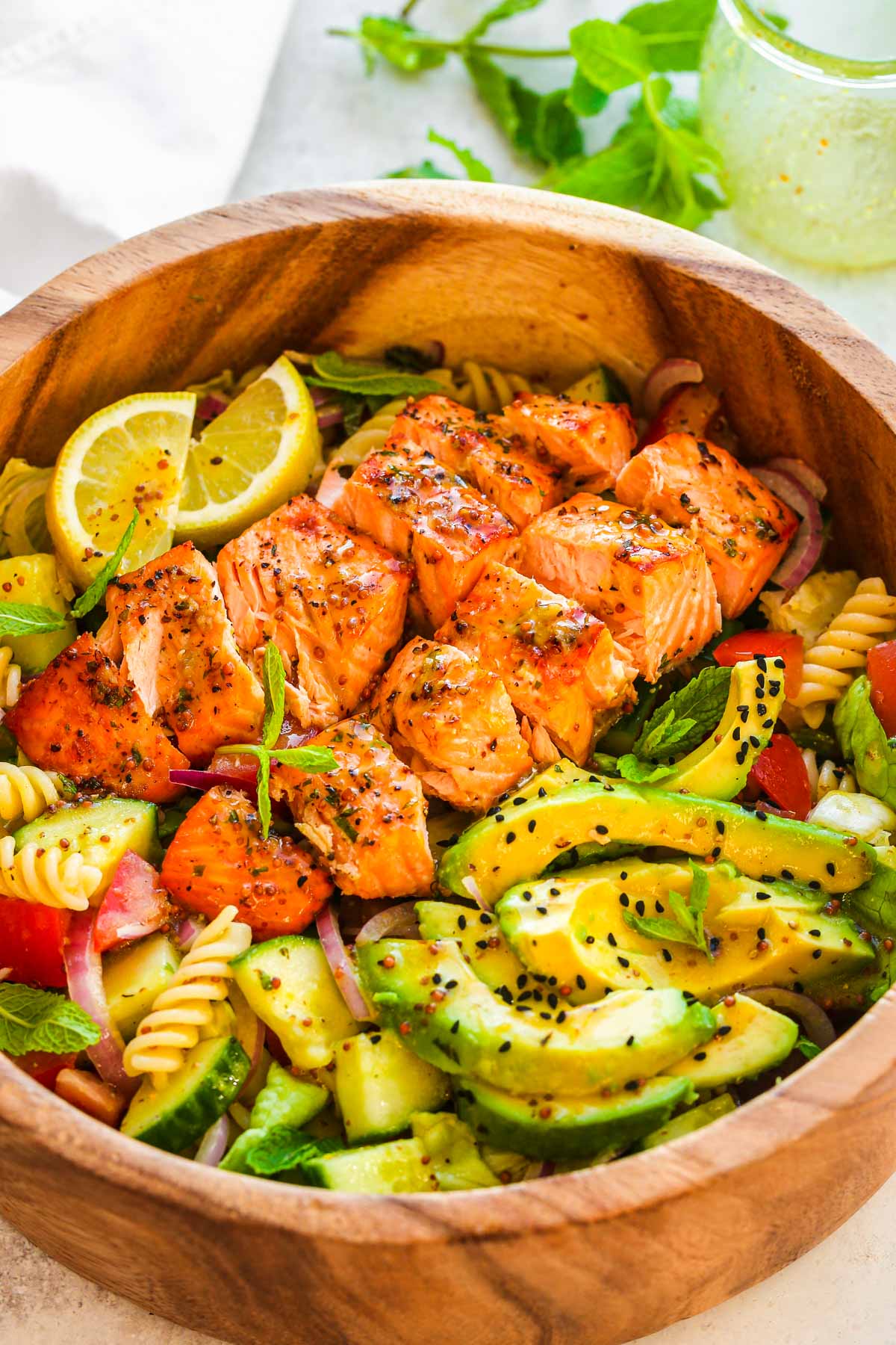 Salmon pasta salad in a wooden serving bowl.