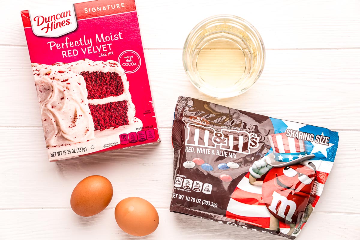 Ingredients used to make 4th of july cookies on a white wood table.